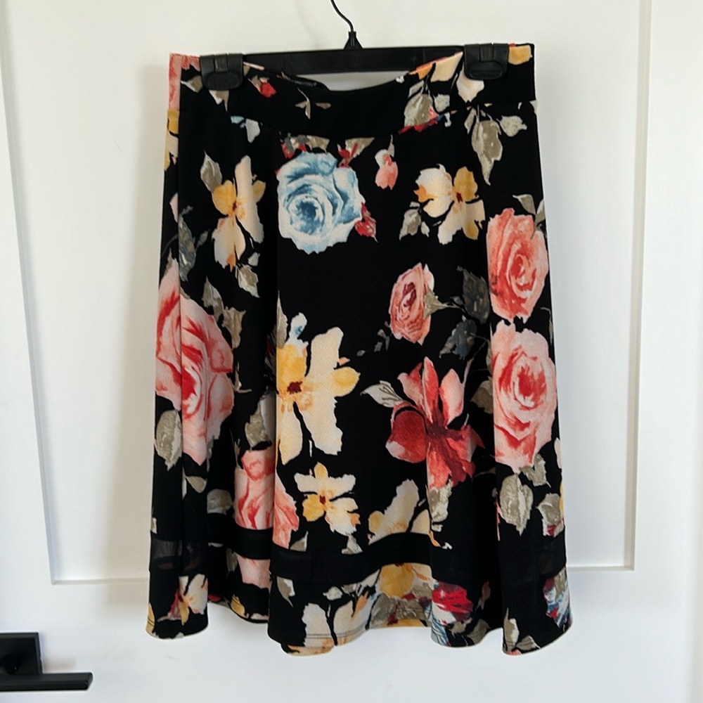 A-line black floral skirt with see through insert near the hem